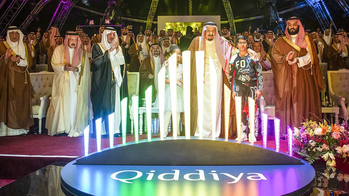 <p>Una imagen proporcionada por el Palacio Real Saudí el 28 de abril de 2018 muestra al rey saudí Salman bin Abdulaziz (CR) y a su hijo, el príncipe heredero Mohamed bin Salman (D), abrazando a dos niños mientras están de pie detrás del logotipo de Qiddiya, una ciudad de entretenimiento que abarca 334 kilómetros cuadrados - PHOTO / PALACIO REAL SAUDÍ / BANDAR AL-JALOUD  </p>
