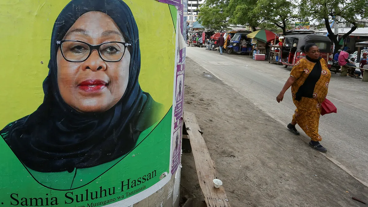 <p paraid="45476899" paraeid="{a56998a0-9495-495e-849e-d944bc64ed17}{41}">Una mujer pasa junto a un cartel electoral de la presidenta de Tanzania, Samia Suluhu Hassan, del partido gobernante Chama Cha Mapinduzi (CCM), colocado en la calle antes de las elecciones generales en el distrito de Ilala, en Dar es Salaam, Tanzania, el 28 de octubre de 2025 - REUTERS/ EMMANUEL HERMAN </p>
