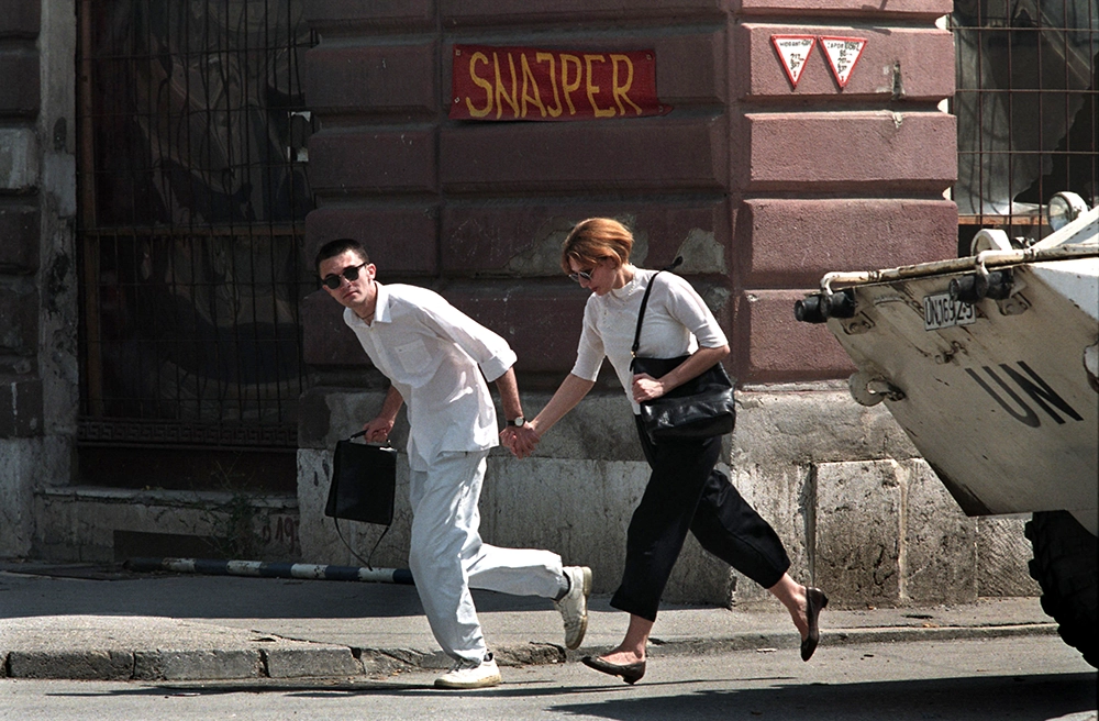 Una joven pareja corre por la infame Avenida de los Francotiradores en Sarajevo, en esta fotografía de archivo del 1 de enero de 1995. El tribunal de crímenes de guerra de las Naciones Unidas dictará su veredicto el 24 de marzo de 2016 en el juicio contra el líder serbobosnio Radovan Karadzic por genocidio durante la guerra de Bosnia de 1992-95 - REUTERS/ PETER ANDREWS