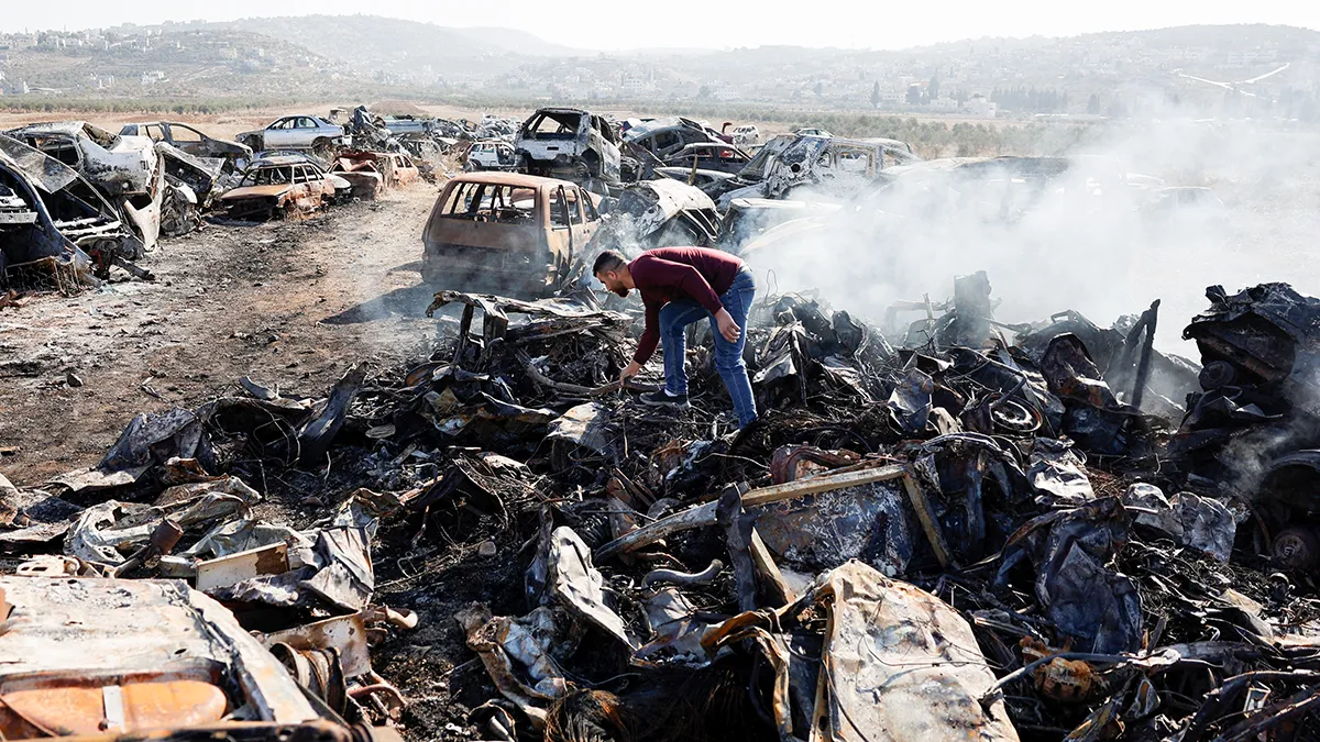 Un palestino, Yahya Dalal, de 32 años, inspecciona coches quemados en un ataque de colonos israelíes en Huwara, en la Cisjordania ocupada por Israel, el 21 de noviembre de 2025 - REUTERS/ AMMAR AWAD