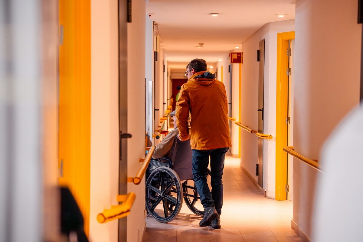 Daniel García llevando a Luciano a su habitación. © Fundación ”la Caixa”