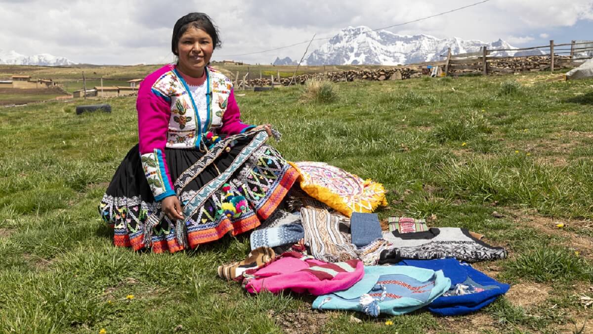 Marleny, lideresa de la organización ATIPTALLA, muestra con orgullo los tejidos y prendas elaboradas con lana de alpaca, que son ofrecidos a los visitantes. © Fundación CODESPA