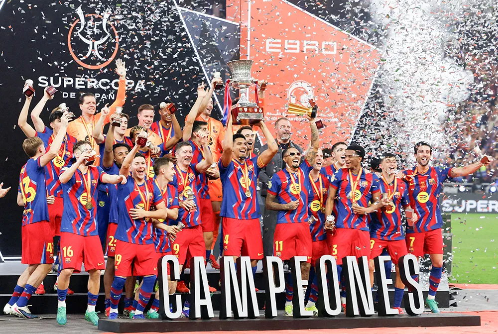 <p>Ronald Araujo, del FC Barcelona, levanta el trofeo junto a sus compañeros tras ganar la final de la Supercopa de España - REUTERS/ VINCENT WEST </p>
