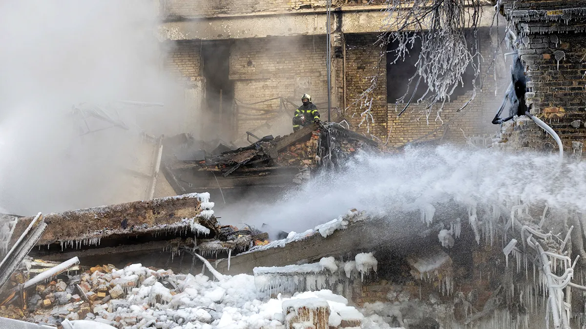 <p>Un bombero trabaja en el lugar donde un dron ruso ha impactado contra un edificio, en medio del ataque de Rusia contra Ucrania, en Kiev, Ucrania, el 12 de enero de 2026 - REUTERS/ THOMAS PETER</p>
