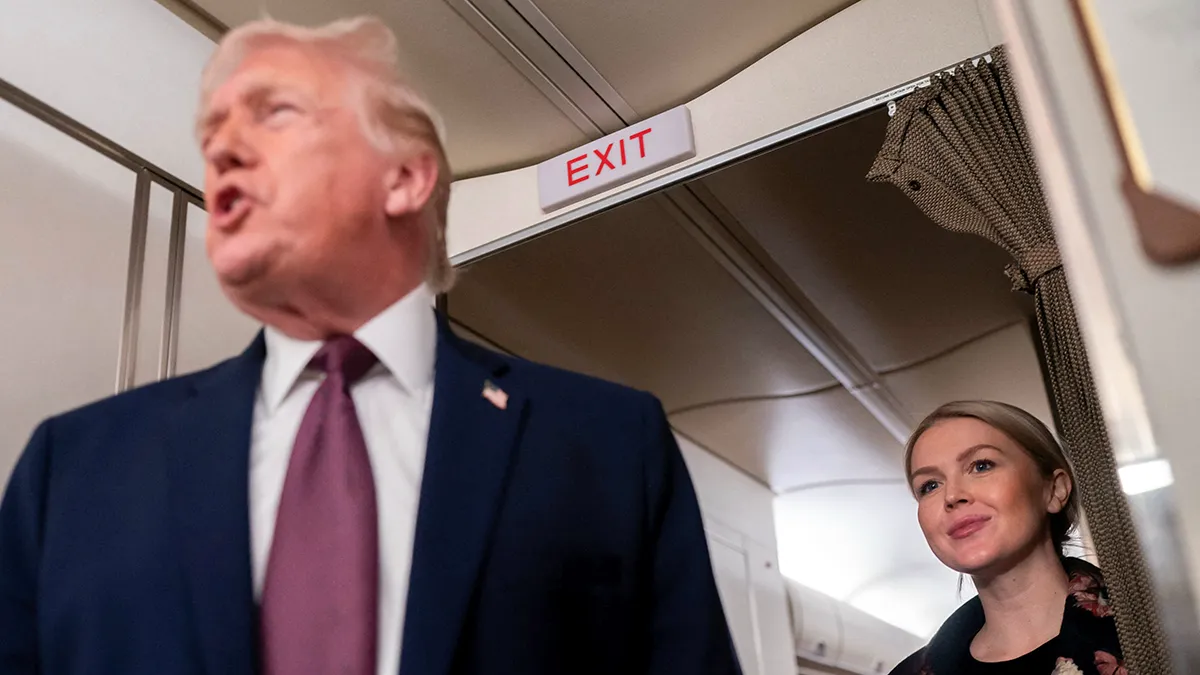 <p>La secretaria de prensa de la Casa Blanca, Karoline Leavitt, escucha mientras el presidente de los Estados Unidos, Donald Trump, habla con miembros de los medios de comunicación a bordo del Air Force One, de camino desde Florida a la Base Conjunta Andrews, Maryland, EE. UU., el 11 de enero de 2026 - REUTERS/ NATHAN HOWARD</p>
