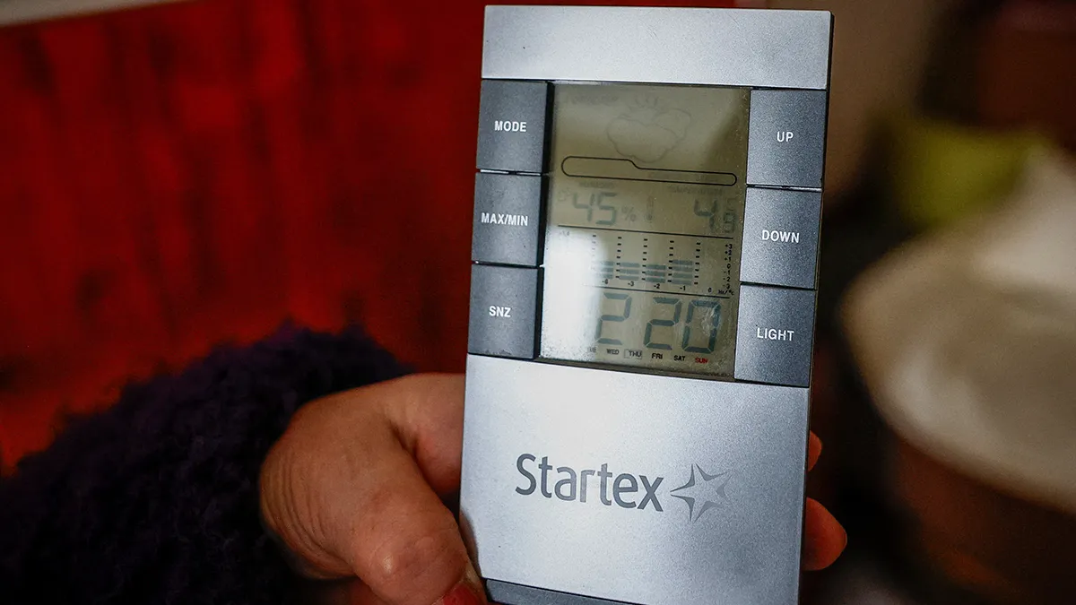 Viktoriia Kostiuchenko, de 69 años, muestra una lectura de termómetro digital de casi 5°C (alrededor de 41°F) dentro de su apartamento, después de que infraestructura civil crítica fuera golpeada por recientes ataques con misiles y aviones no tripulados rusos, en medio del ataque de Rusia a Ucrania, en Kiev, Ucrania, el 23 de enero de 2026 - REUTERS/ ALINA SMUTKO