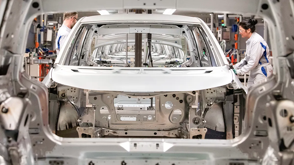 Trabajadores completan una identificación de automóvil eléctrico.3 carrocería en la línea de montaje durante una gira de prensa en la planta del fabricante alemán Volkswagen AG (VW) en Zwickau, Alemania - AP/ JENS MEYER
