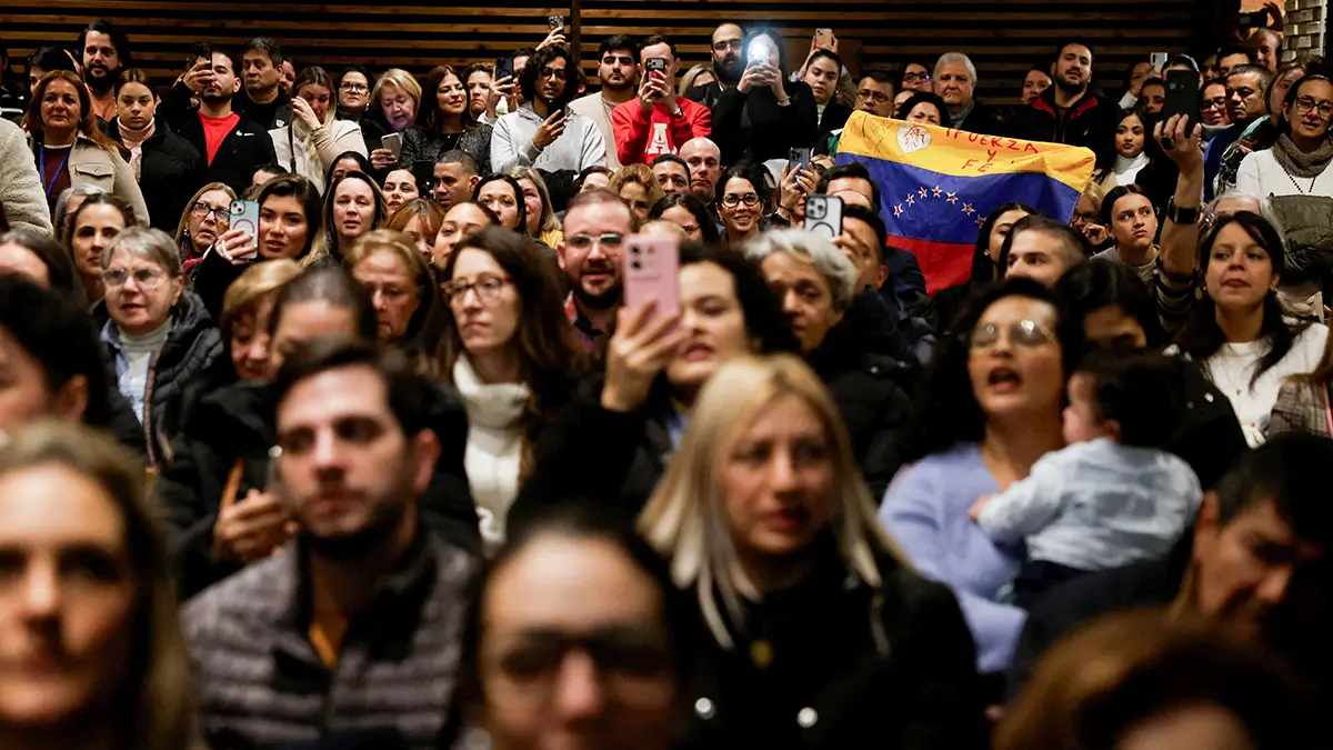 Las palabras "Fuerza y fe" están escritas en una bandera venezolana mientras personas, la mayoría de ellas miembros de la diáspora venezolana, asisten a una misa en honor a la Virgen Católica de la Divina Pastora mientras el gobierno de Venezuela comienza a liberar a los detenidos, en Madrid, España, el 14 de enero de 2026 - REUTERS/ SUSANA VERA