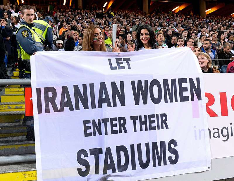 En esta foto de archivo tomada el 31 de marzo de 2015, dos mujeres sostienen una pancarta que dice: ‘Dejen que las mujeres iraníes entren en sus estadios' durante el partido amistoso internacional de fútbol entre Suecia e Irán en el Friends Arena de Solna, cerca de Estocolmo