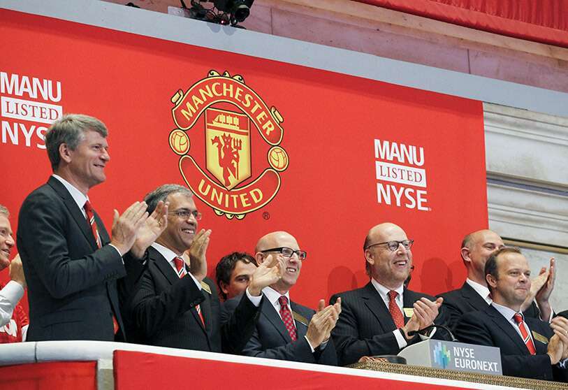 Los ejecutivos y propietarios del Manchester United Joel (3º izq) y Avram Glazer (2º Der) tocan la campana de apertura en celebración de la oferta pública inicial del Manchester United en la Bolsa de Valores de Nueva York