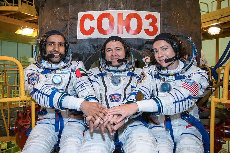 Hazzaa Ali Almansoori, de los Emiratos Árabes Unidos (izq.) y sus compañeros de tripulación de la Expedición 61, Oleg Skripochka, de Roscosmos (centro), y Jessica Meir, de la NASA (derecha), posan para las fotos del 11 de septiembre frente a su nave espacial Soyuz MS-15